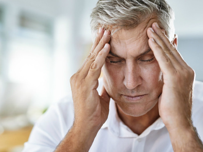 Man with a headache rubbing forehead